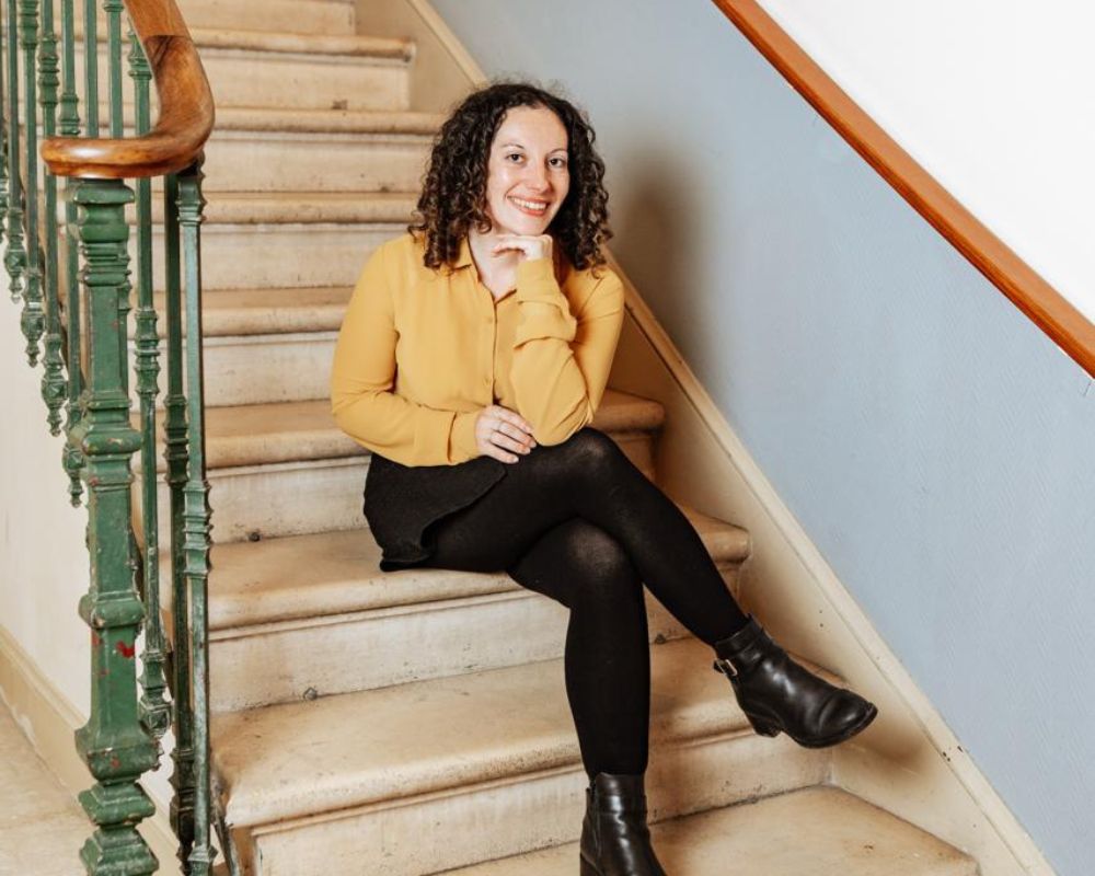 Chloé LASSALLE, consultante en communication assise dans un escalier.